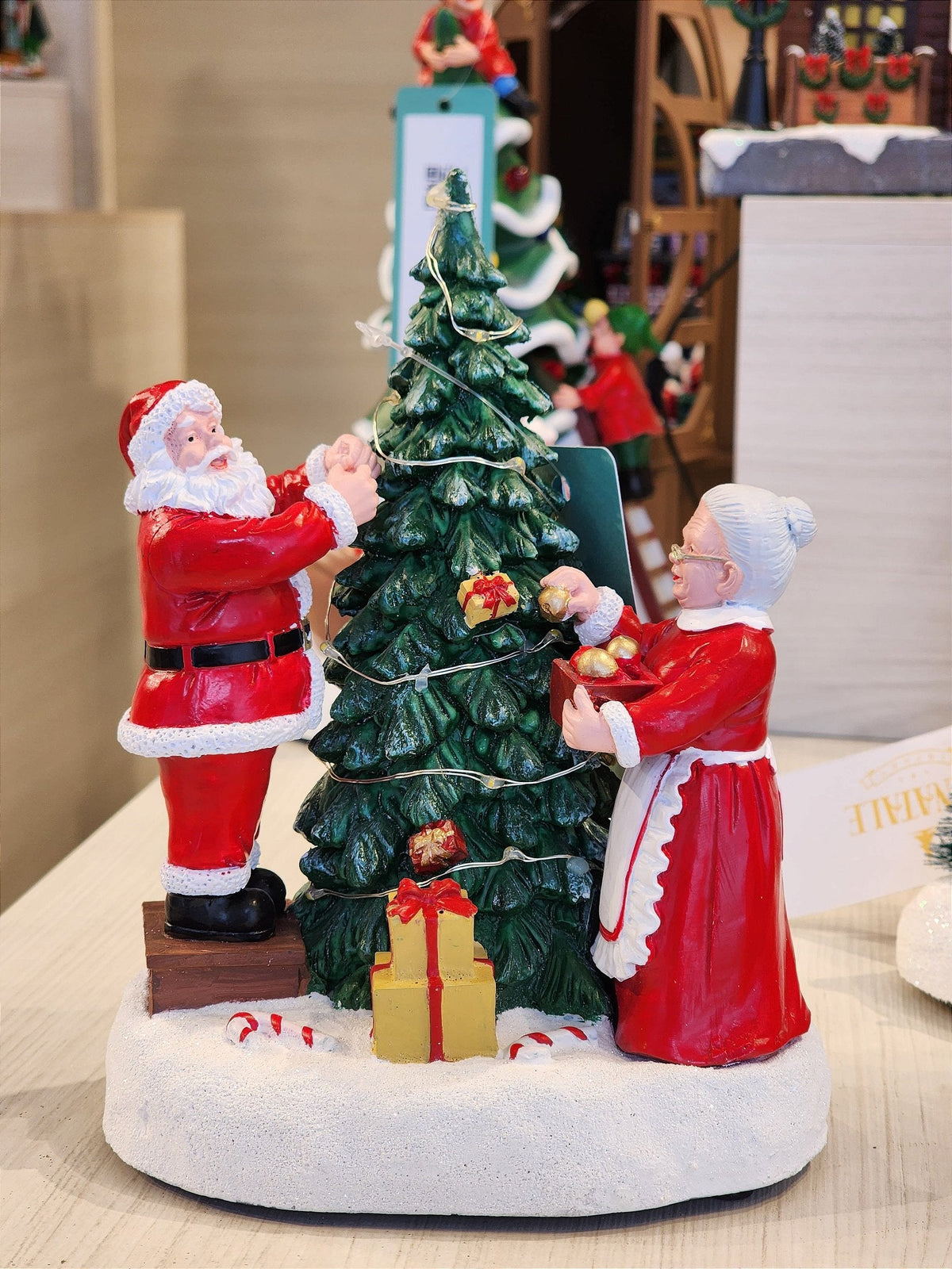 CENÁRIO VILA NATALINA PAPAI E MAMÃE NOEL MONTANDO A ÁRVORE 28CM - PRÉ VENDA 2025